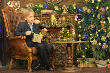 Obraz premium Portrait of little boy with gift on Christmas