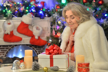 Obraz na płótnie Canvas Happy smiling senior woman with gift on Christmas