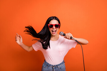 Photo of optimistic brunette lady sing in mic wear spectacles pink t-shirt isolated on bright...