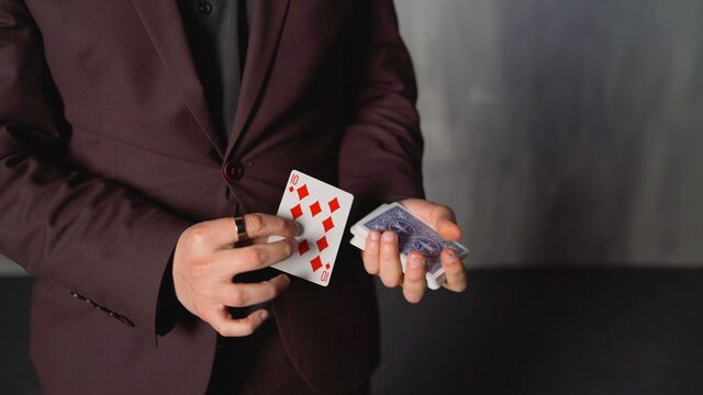 Young boy in magician costume with cards. Trick with playing cards.