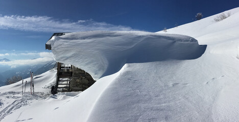 Fototapeta na wymiar view on a chelet coverd with snow on alpine mountain with touring ski on the snow