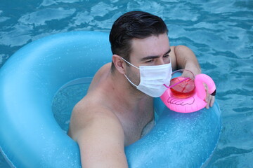 Properly protected tourist drinking cocktail during pandemic