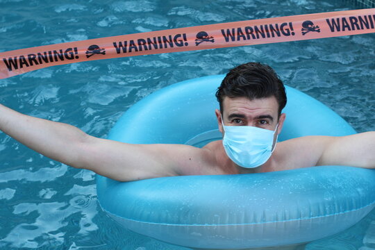 Stressed out tourist in swimming pool during pandemic
