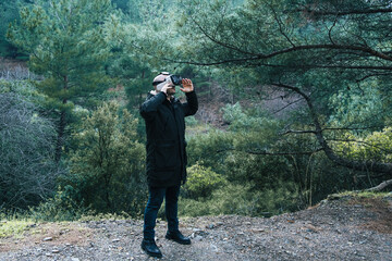 Man examining the forest with virtual reality glasses. Future technology vr 3D glasses to be used anywhere