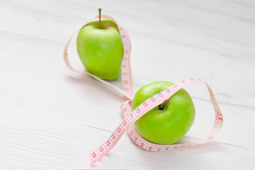 Measuring tape wrapped around two green apple isolated on white background, Concept of the goal to lose weight,the goal of diet