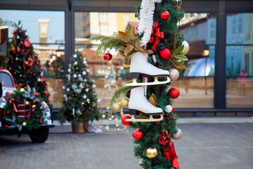 Pair of figure skates hanging on a festive christmas pole in a city park