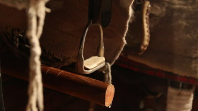 A horse saddle and stirrups. Horse saddle for a western cowboy. A leather frame and metal stirrups