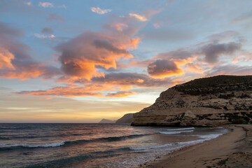 beautiful ocean sunset on the Costa del Sol in Spain with beach and cliffs in the background