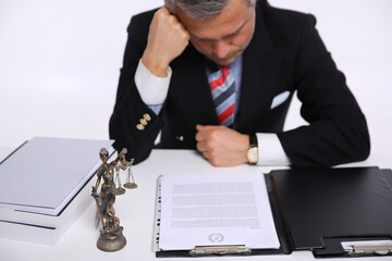 A lawyer at the table and a sculpture Lady Justice.