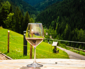 Glass of  white wine on a rocky mountain background. Hiking in Dolomites, South Tyrol, northern Italy