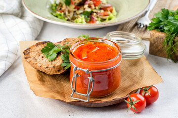 Homemade lecho in a glass jar with a lid filmed in decor