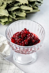 Soaked lingonberries in a transparent vase on a white background