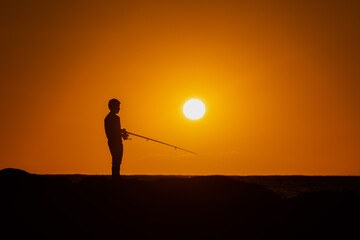 silhouette of a fisherman