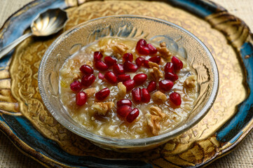 Ashure or Noah's pudding, the turkish dessert porridge in glass bowl on golden dish