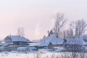 Russian village with old wooden traditional Russian style. Roofs covered by snow during frosty winter day.