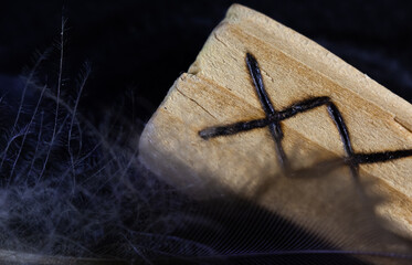 close-up on a wooden rune through a small feather