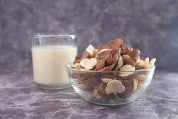 Close up of chocolate corn flakes and glass of milk on black 