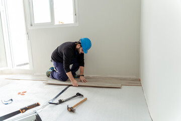 Man worker assembling laminate flooring.