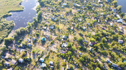 Drone fly over waving river of blue color surrounded by local village with various buildings and Wetland and marsh habitat with a reedbed of Common Reed aerial view.