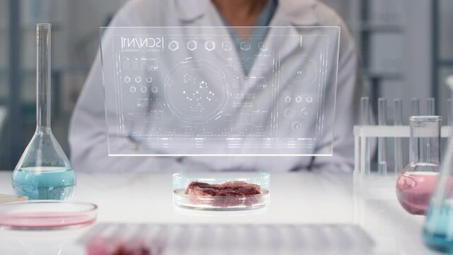 CGI of holographic image analysis appearing above artificial meat sample in petri dish placed on lab table by unrecognizable male microbiology scientist. Futuristic research method concept