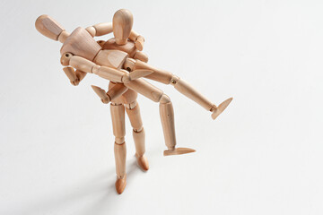 one wooden mannequin holding another in his arms