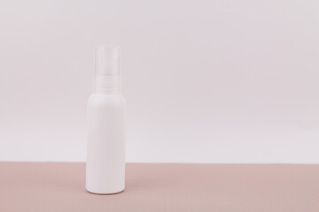 white bottle without an inscription on a light background for perfume or antiseptic gel