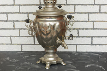 Metal Russian samovar on wood. Tea drinking tradition, vintage teapot. Close-up