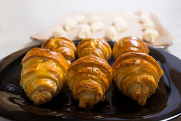 Bked and raw croissants. Baking sweet buns.