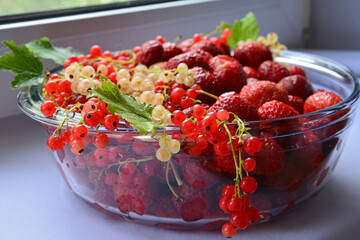Berries close-up. Currants and strawberries with glassware. Diet healthy natural food. Berry fruit background. Side view.