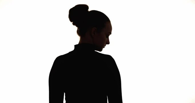 Sad woman silhouette. Female loneliness. Regret sorrow. Despair melancholy. Dark contrast back view shape of upset hopeless low key lady turning head isolated on white copy space background.