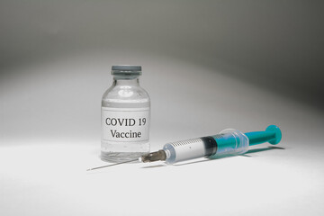 Covid 19 vaccine bottle and syringe on a white background.
