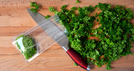 Harvesting fresh parsley for the winter and packing with bags. Greens on a cutting board.