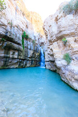 Flowing water to a large pool of clear water, in the hidden waterfall in Nahal Arugot, Ein Gedi Israel route