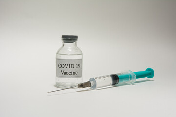 Covid 19 vaccine bottle and syringe on a white background.