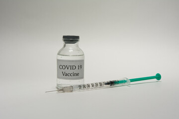 Covid 19 vaccine bottle and syringe on a white background.