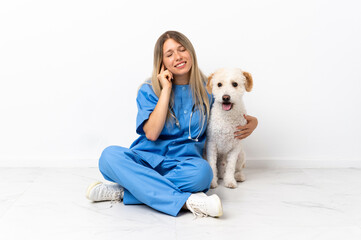 Young veterinarian woman with dog sitting on the floor frustrated and covering ears
