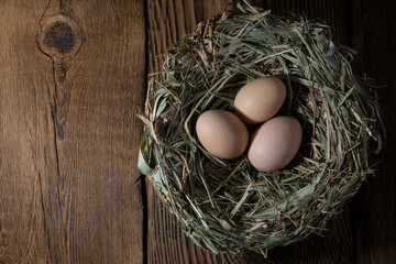 Easter eggs in a basket on a vintage wooden background. eggs in the nest with copy space