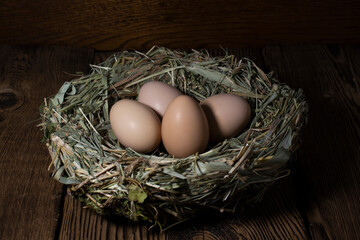 Easter eggs in a basket on a vintage wooden background. eggs in the nest with copy space