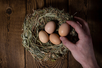 easter basket with eggs in hands on vintage wooden background