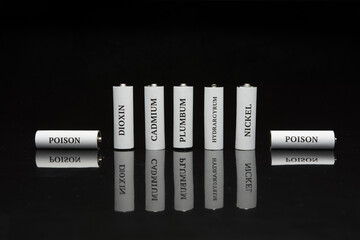 Battery on a black background. Ecology. Harm to nature from batteries.
