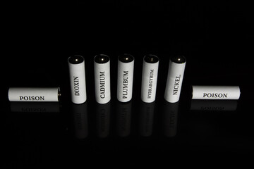 Battery on a black background. Ecology. Harm to nature from batteries.