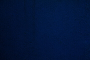 texture of a dark blue wall covered with volumetric plaster, space for text, space for copy