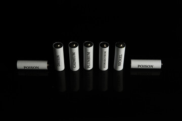 Battery on a black background. Ecology. Harm to nature from batteries.