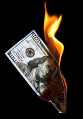 One Hundred Dollars are burning on a black