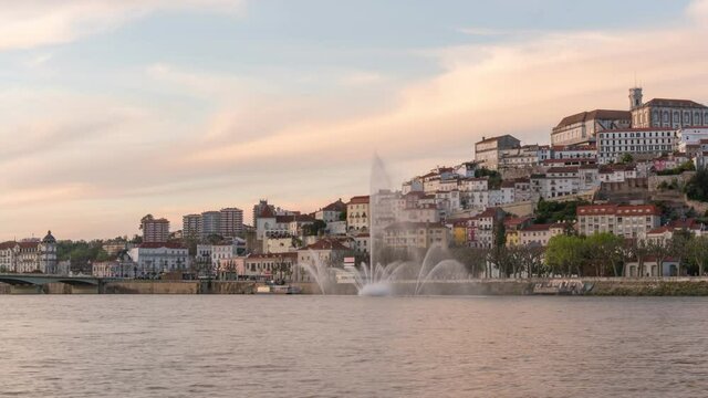 Timelapse of Coimbra at sunset with color light fountain in mondego river, in Portugal
