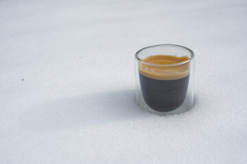 Expresso dans une tasse transparente posée sur la neige