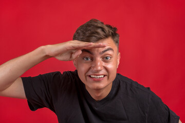 Young handsome man over isolated background very happy and smiling looking far away with hand over head. Searching concept.