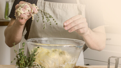 A male baker kneads bread dough in his kitchen. Home baker