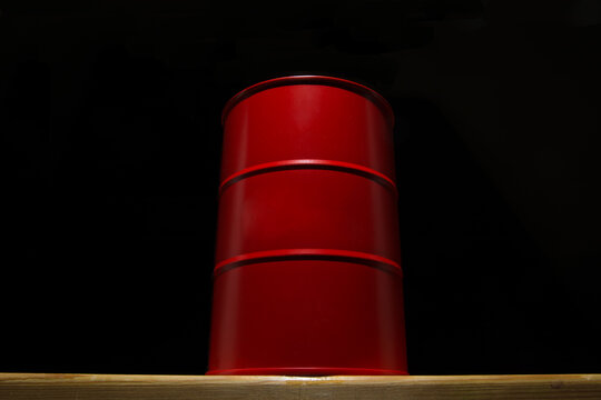 Red barrel of oil on a black background.