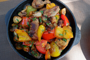 Home-style roast. Meat skillet with tomatoes and bell pepper